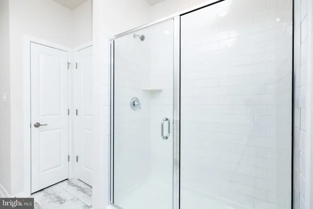 a bathroom with a shower and a glass door