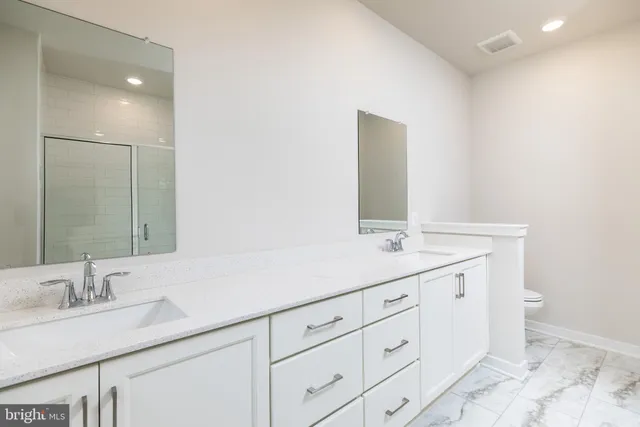 a bathroom with a double vanity sink and a mirror