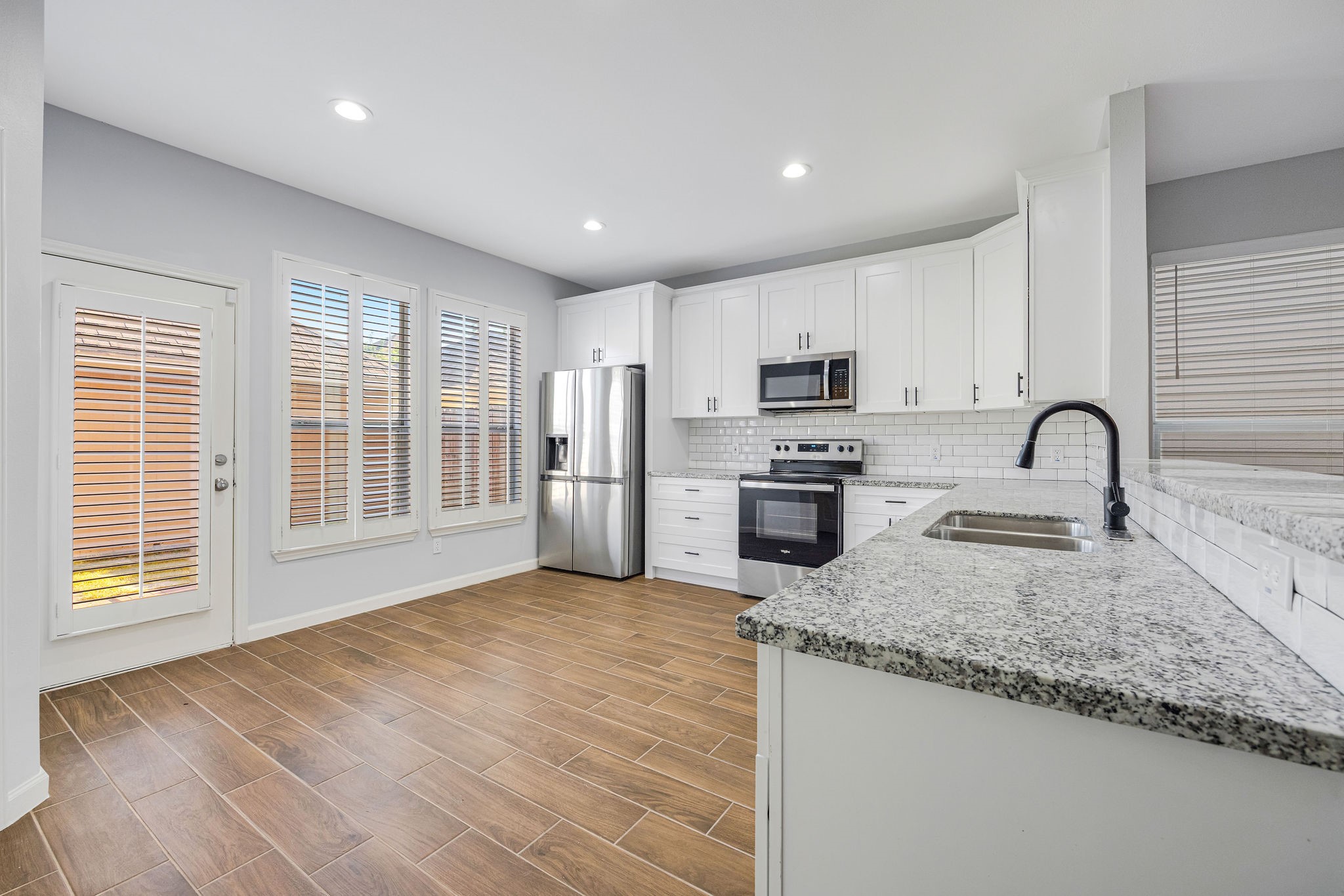 8018 Grow Lane Houston, TX 77040 - Photo 6 of 20 Stunning modern kitchen with granite counters, stainless steel appliances, and abundant natural light.