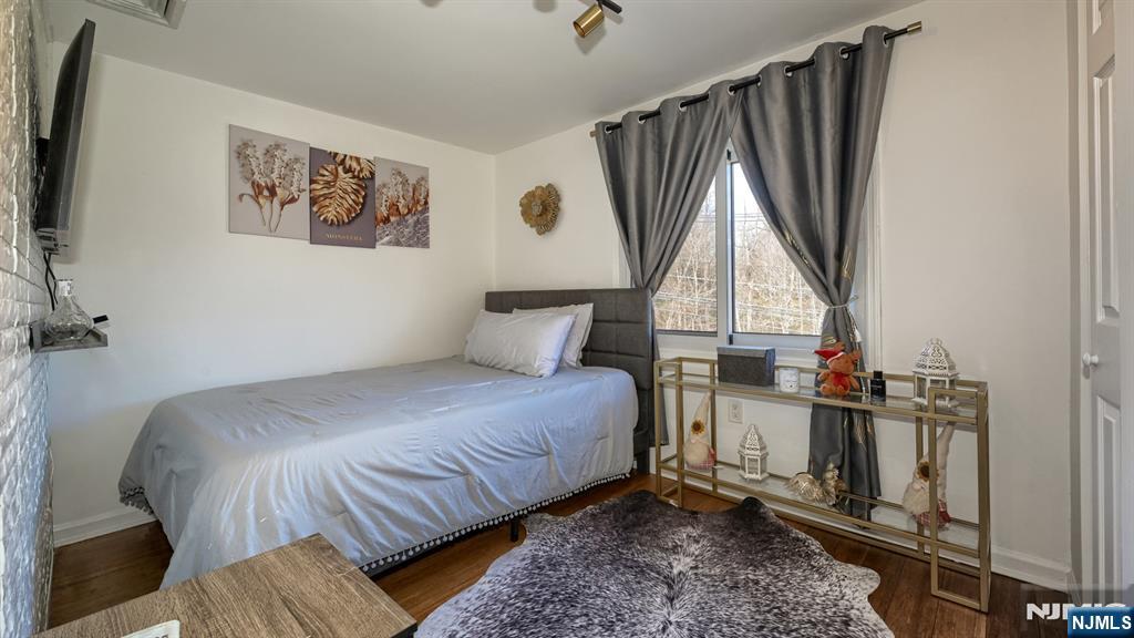224 Pompton Road Haledon, NJ 07508 - Photo 26 of 34 a bedroom with a bed a flat screen tv and a window