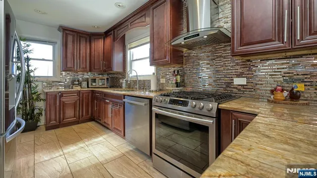 a kitchen with stainless steel appliances granite countertop a stove a sink dishwasher and a refrigerator