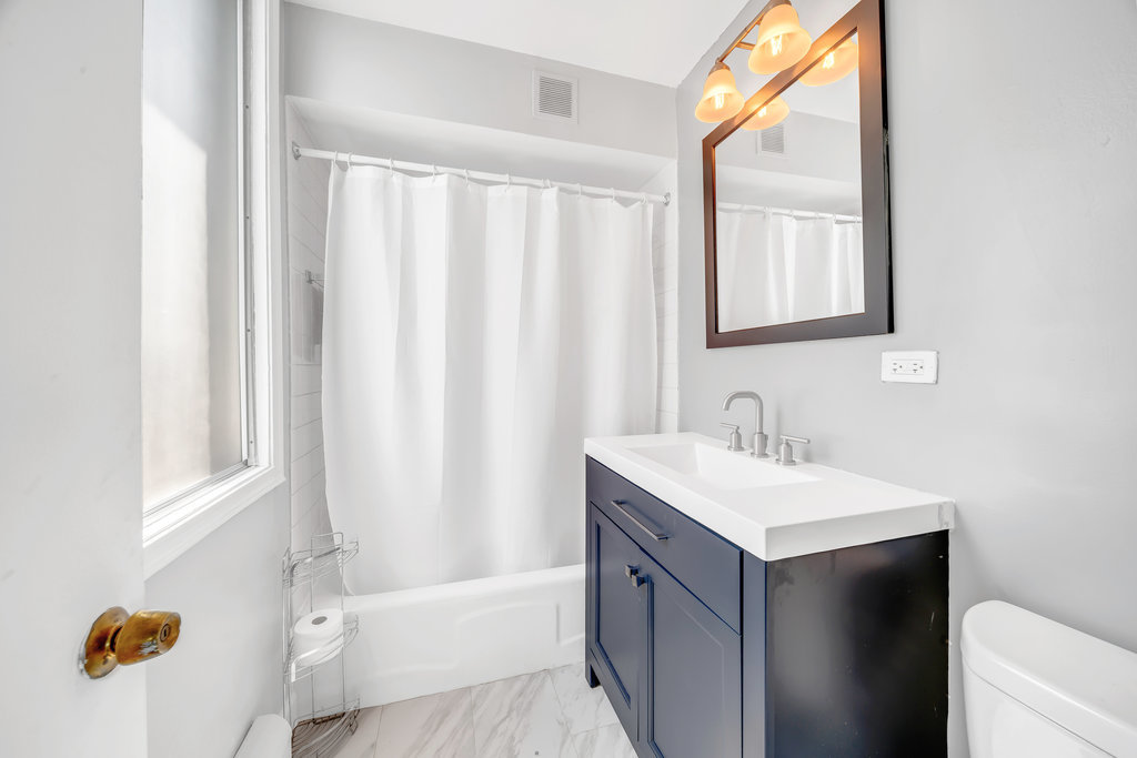 6325 North Sheridan Road, Unit 1903 Chicago, IL 60660 - Photo 13 of 20 a bathroom with a sink a mirror and a bathtub
