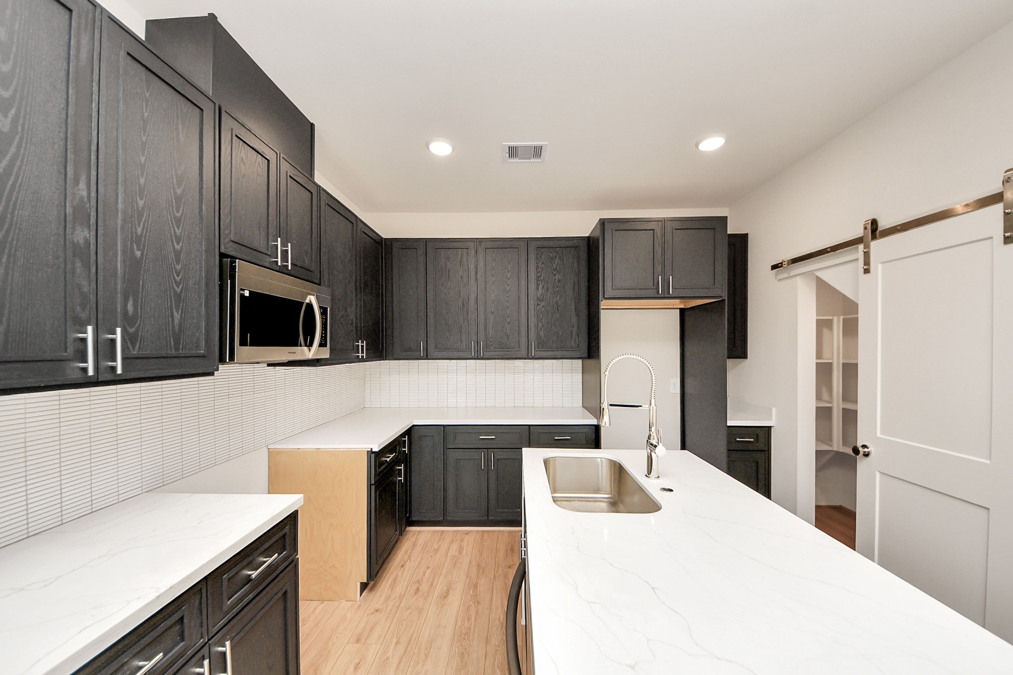 5903 Urban Pines Street Houston, TX 77091 - Photo 35 of 42 a kitchen with stainless steel appliances kitchen island a refrigerator sink and microwave