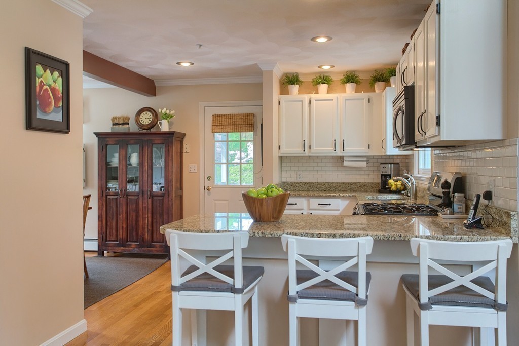 39 Elm Ridge Road Stow, MA 01775 - Photo 8 of 30 a kitchen with a dining table chairs and cabinets