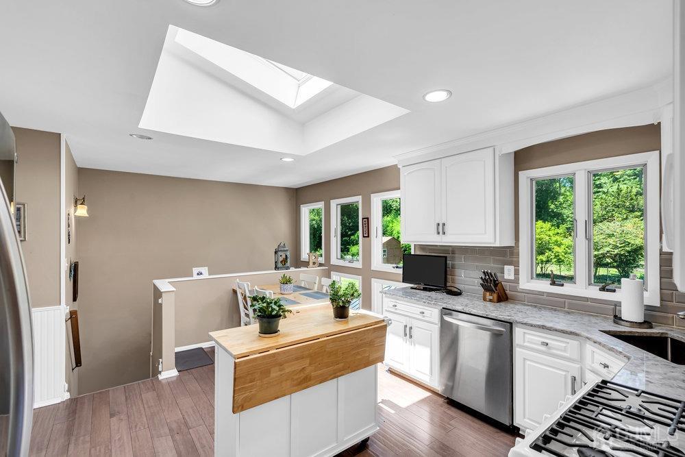 24 Chandler Road Edison, NJ 08820 - Photo 11 of 30 a kitchen with a stove a refrigerator sink dishwasher and cabinets with wooden floor