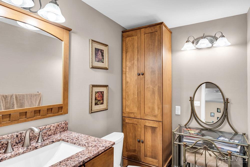 24 Chandler Road Edison, NJ 08820 - Photo 22 of 30 a bathroom with a granite countertop sink mirror vanity and toilet