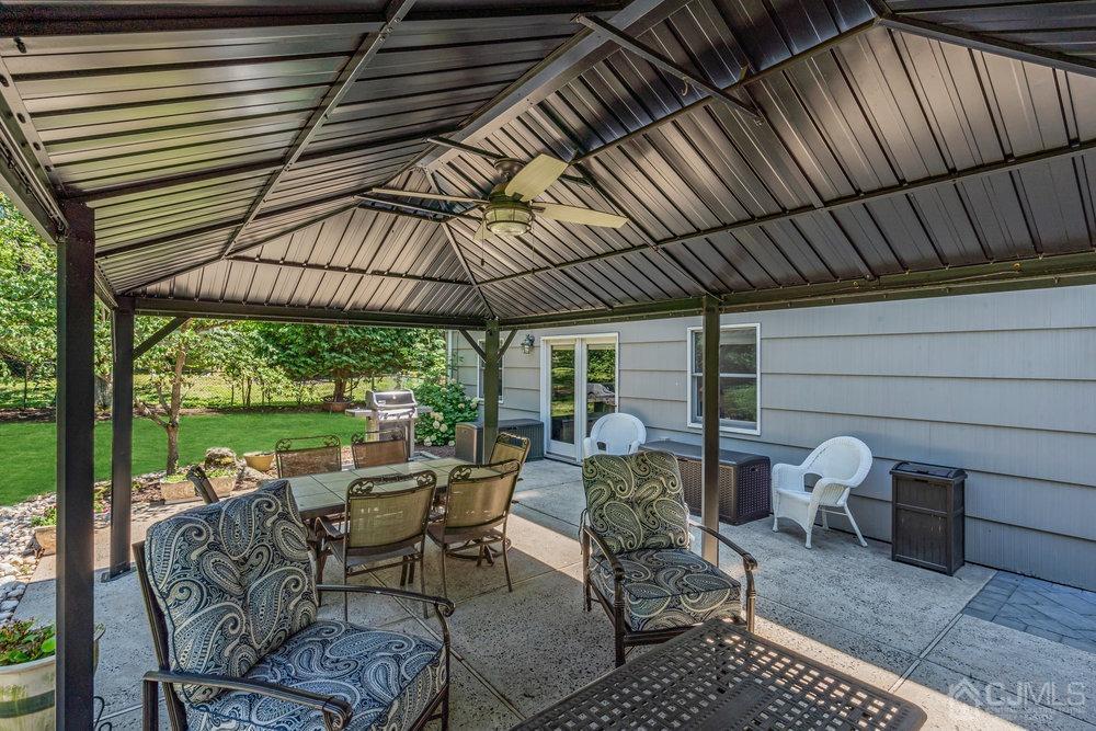 24 Chandler Road Edison, NJ 08820 - Photo 24 of 30 a view of a patio with table and chairs under an umbrella with a barbeque