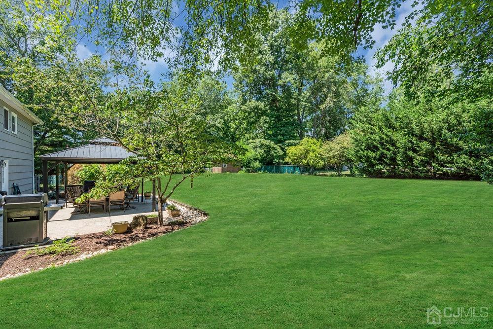 24 Chandler Road Edison, NJ 08820 - Photo 26 of 30 a view of patio with table and chairs under an umbrella