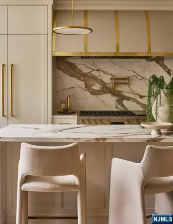 a view of a kitchen with kitchen island a stove a refrigerator a sink and a dining table with wooden floor