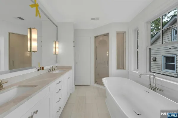 a white bath tub sitting in a bathroom next to a window