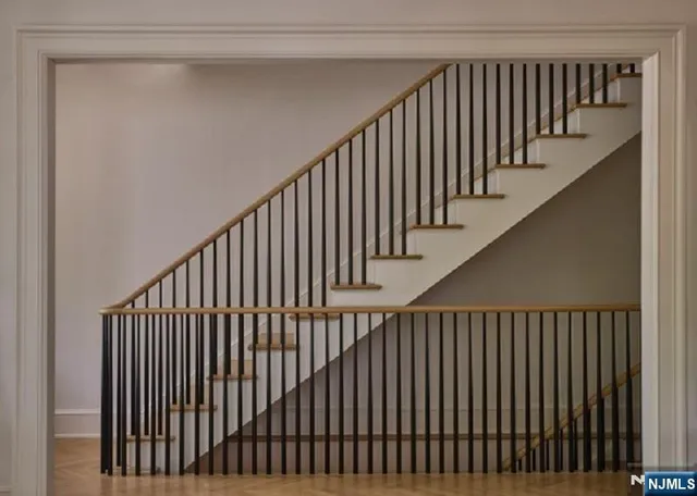 a view of staircase with railing and white walls