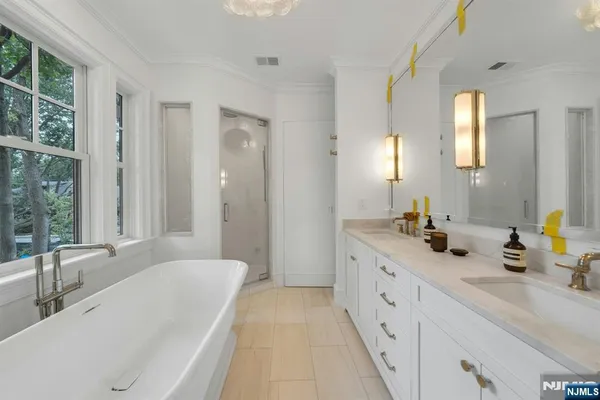 a white bath tub sitting in a bathroom next to a window