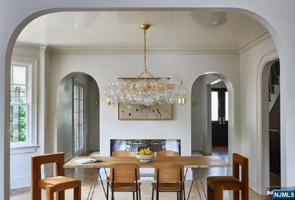 a view of a dining room with furniture a chandelier and wooden floor