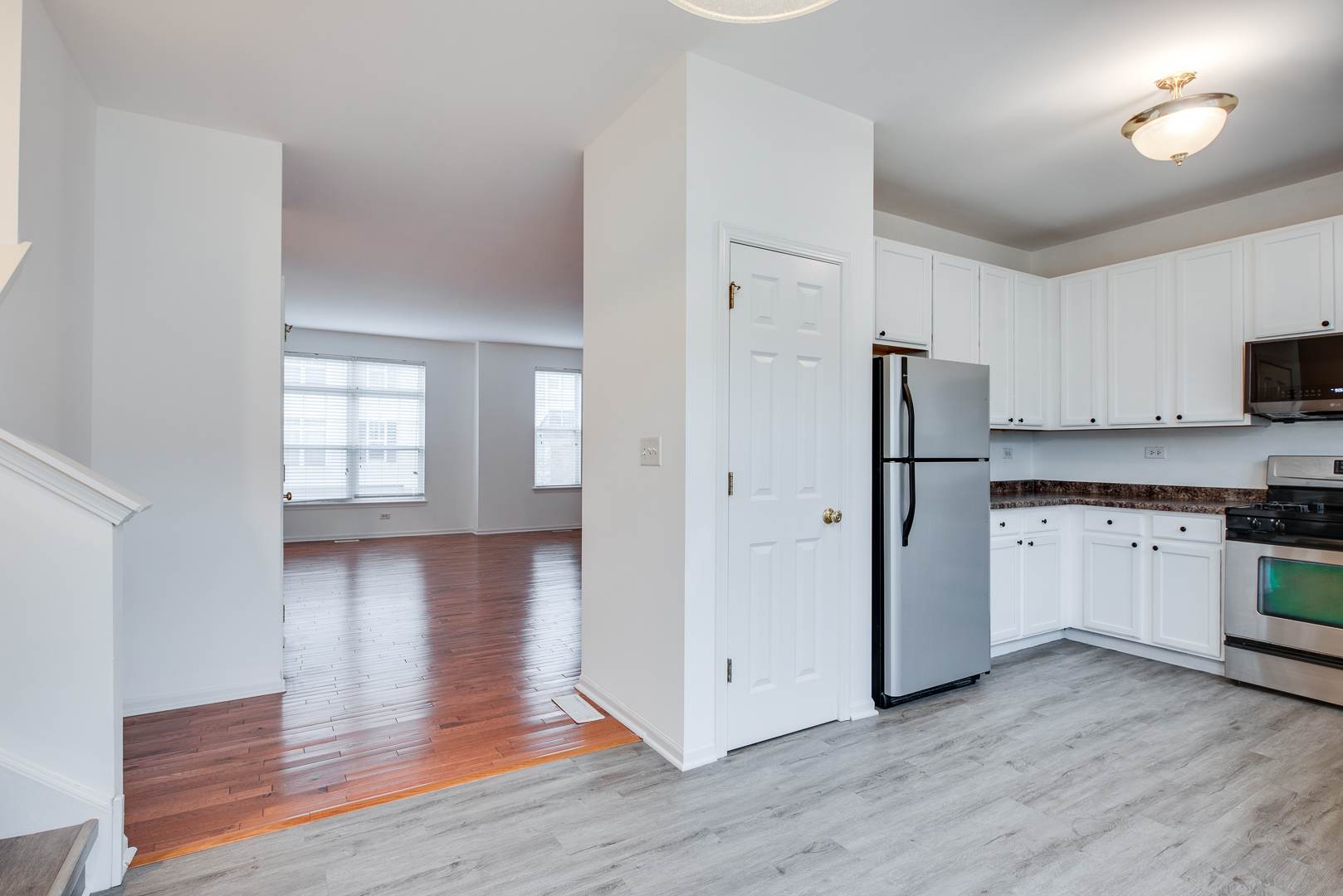 401 North Commerce Street, Unit 401 Aurora, IL 60504 - Photo 11 of 20 a kitchen with white cabinets and wooden floor