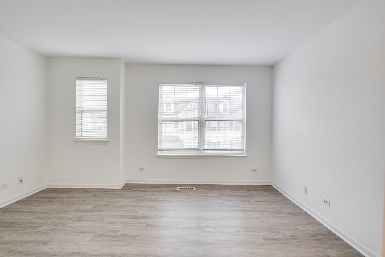 401 North Commerce Street, Unit 401 Aurora, IL 60504 - Photo 2 of 20 an empty room with wooden floor and windows