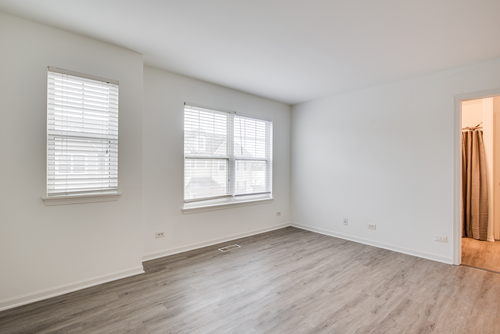401 North Commerce Street, Unit 401 Aurora, IL 60504 - Photo 4 of 20 an empty room with wooden floor and windows