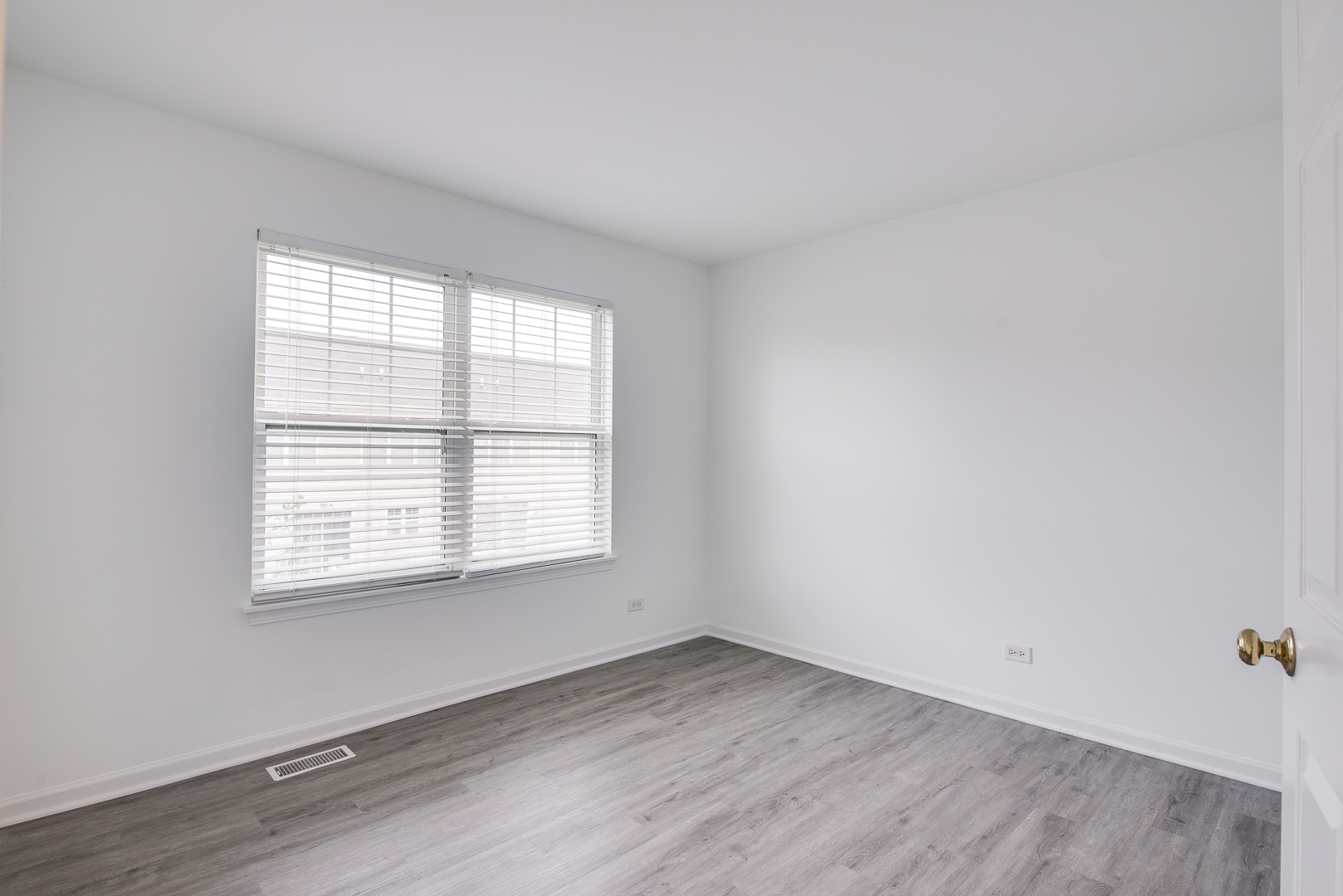 401 North Commerce Street, Unit 401 Aurora, IL 60504 - Photo 9 of 20 an empty room with wooden floor and windows
