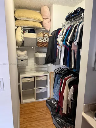 a view of walk in closet with clothes and shoes