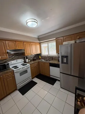 a kitchen with a stove a sink and a refrigerator