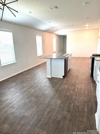 a large kitchen with a lot of counter space and a wooden floor
