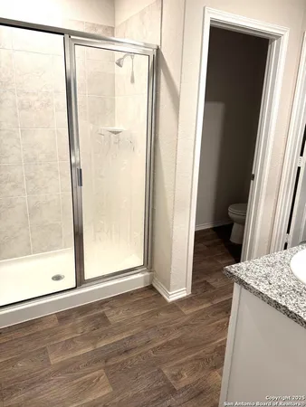 a bathroom with a granite countertop shower and a sink