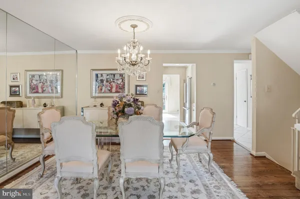 a view of a dining room with furniture a chandelier and wooden floor