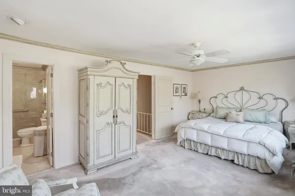 a spacious bedroom with a bed and a chandelier