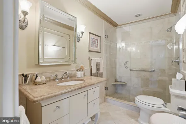 a bathroom with a granite countertop sink toilet and shower