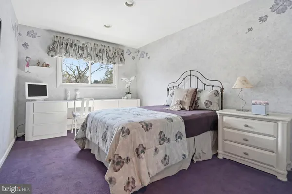 a bedroom with a bed and painting on the wall