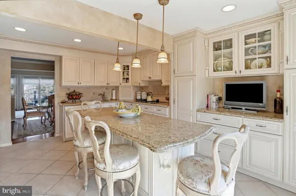 a dining table with chairs and kitchen view