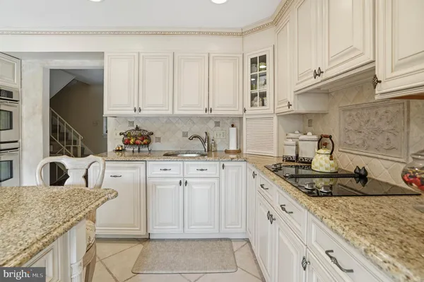 a kitchen with granite countertop a sink stove and cabinets