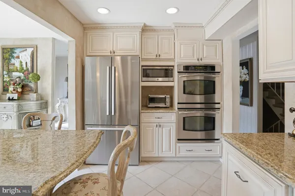 a kitchen with stainless steel appliances granite countertop a refrigerator and a stove top oven