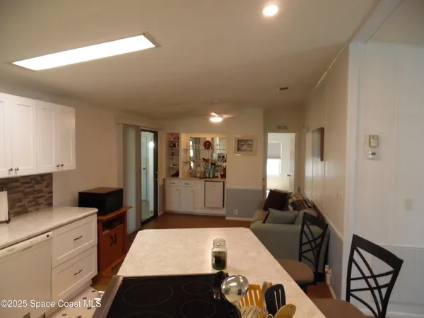 a large tree in a kitchen with a stove a refrigerator a oven with wooden floor