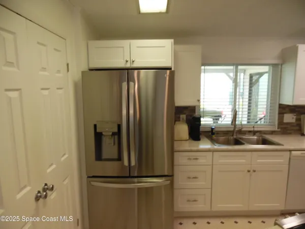a kitchen with appliances a counter space and a window