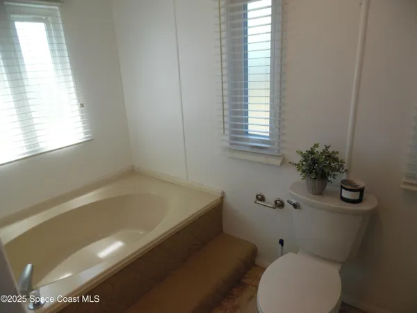 a bath room with a toilet and a bath tub
