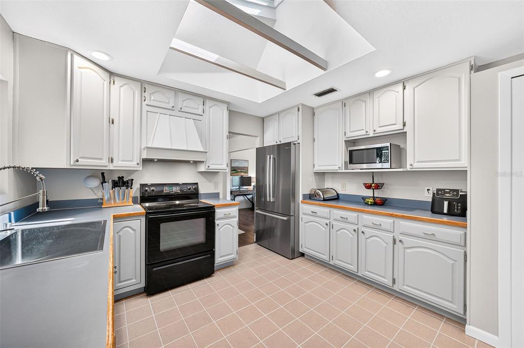 517 Roughbeard Road Winter Park, FL 32792 - Photo 50 of 53 a kitchen with stainless steel appliances granite countertop a stove top oven a sink dishwasher a refrigerator and cabinets with wooden floor