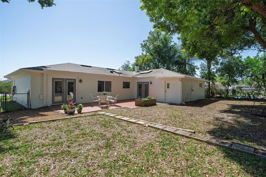 517 Roughbeard Road Winter Park, FL 32792 - Photo 52 of 53 a backyard of a house with table and chairs and large tree