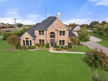 a view of a house with a yard and potted plants