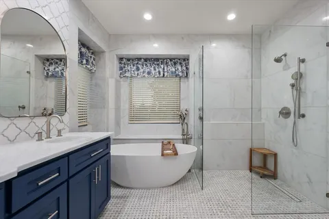 a bathroom with a tub a sink and a shower