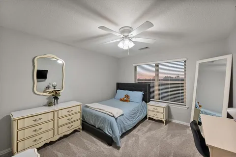 a bedroom with a bed dresser and a window