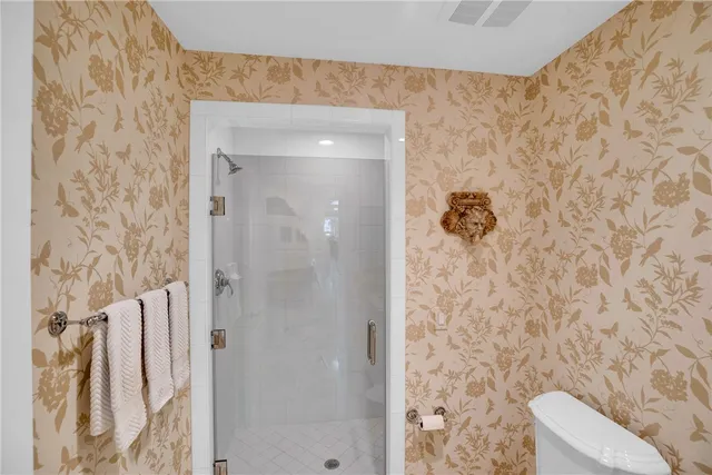 front view of a brick house with a yard and potted plants