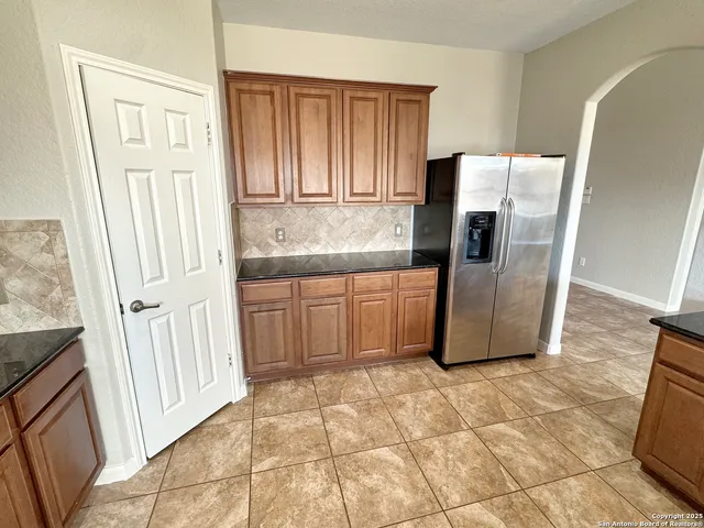 a kitchen with stainless steel appliances granite countertop a refrigerator and a stove
