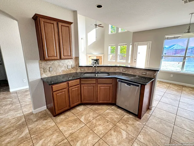 a kitchen with granite countertop a sink stove and cabinets