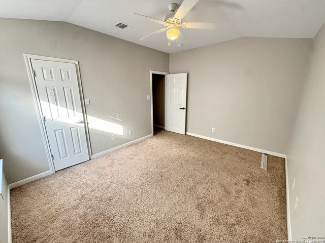 an empty room with windows and fan