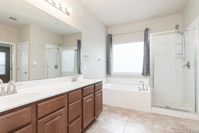 a bathroom with a tub sink and mirror