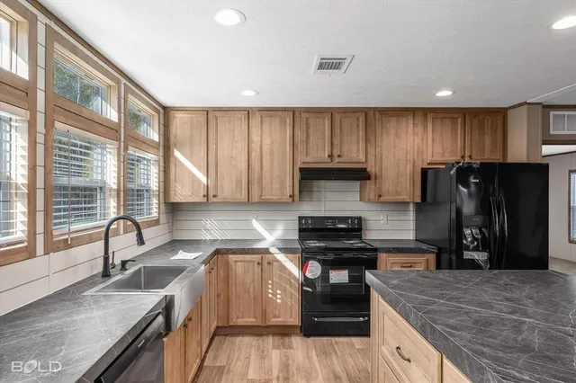 a kitchen with a refrigerator a sink a stove a microwave and island