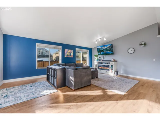 a living room with a couch and a dining table with wooden floor