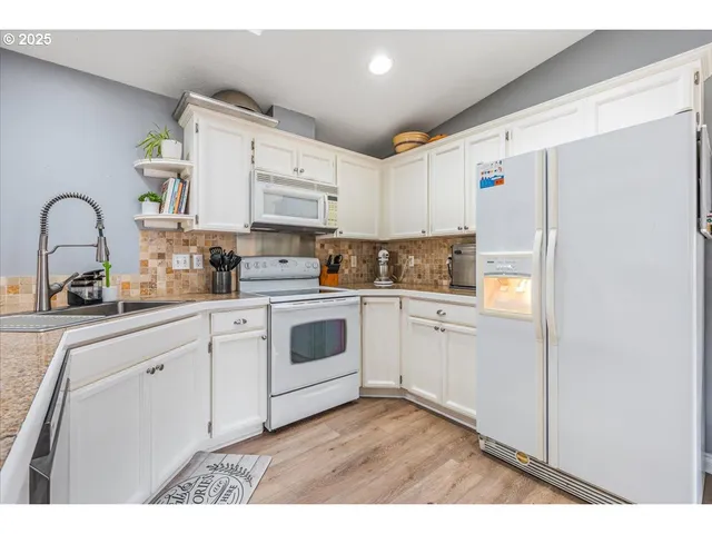 a kitchen with cabinets a sink and white stainless steel appliances