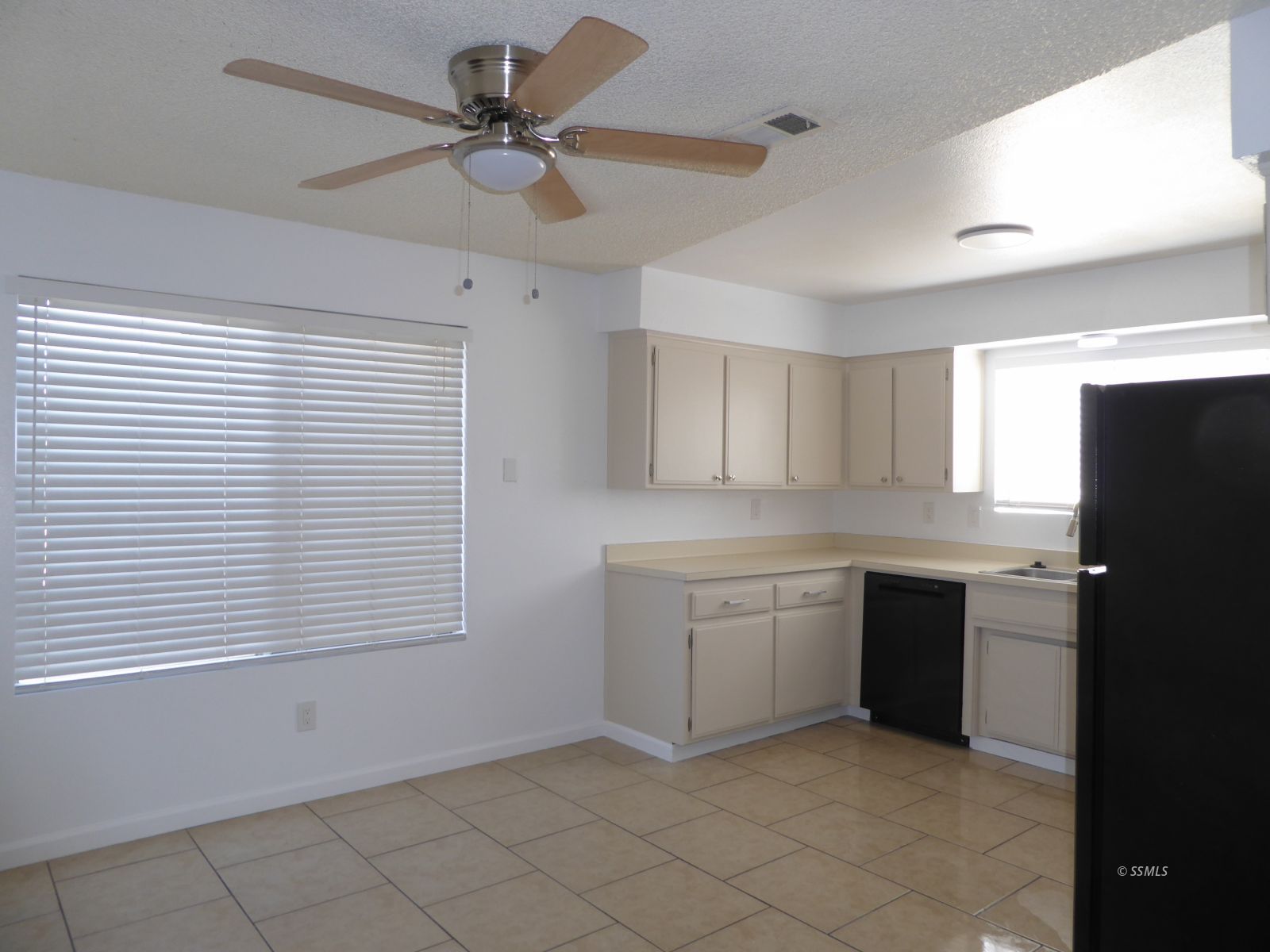 824 C Capehart Court Ridgecrest, CA 93555 - Photo 2 of 11 a kitchen with a refrigerator and white cabinets