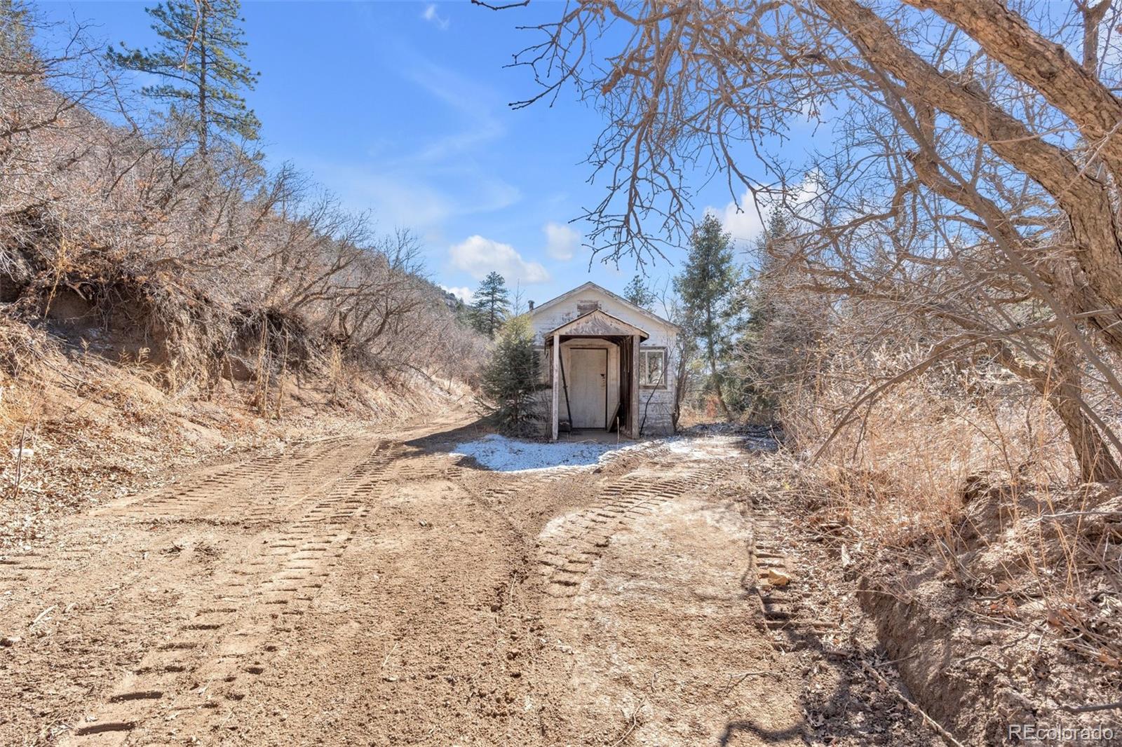 1906 Hidden Valley Road Sedalia, CO 80135 - Photo 18 of 27 a view of a house with a yard covered with snow